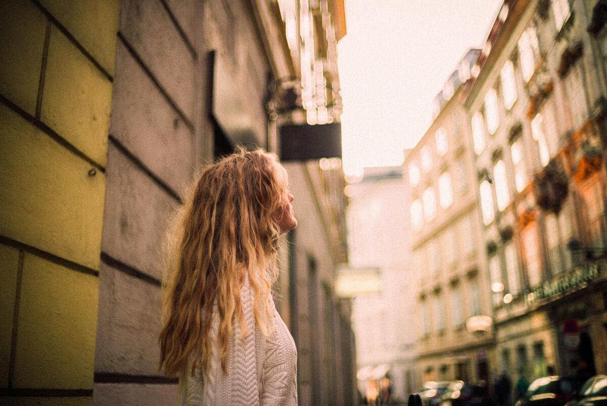 woman standing in a street looking up